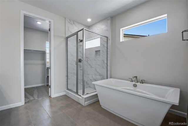 bathroom with separate shower and tub and tile patterned flooring