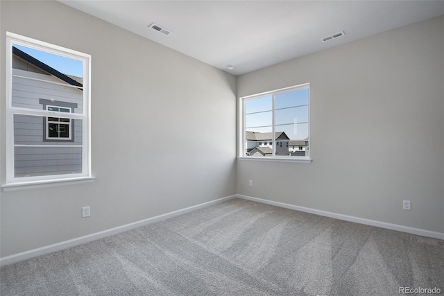 carpeted empty room with baseboards and visible vents