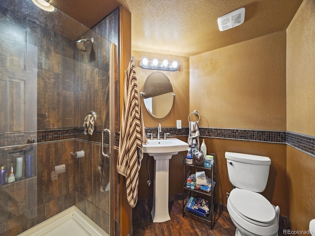 6432 S Robb Ct, Littleton, CO 80127 - full bath featuring toilet, tiled shower, wood finished floors, a textured wall, and a textured ceiling
