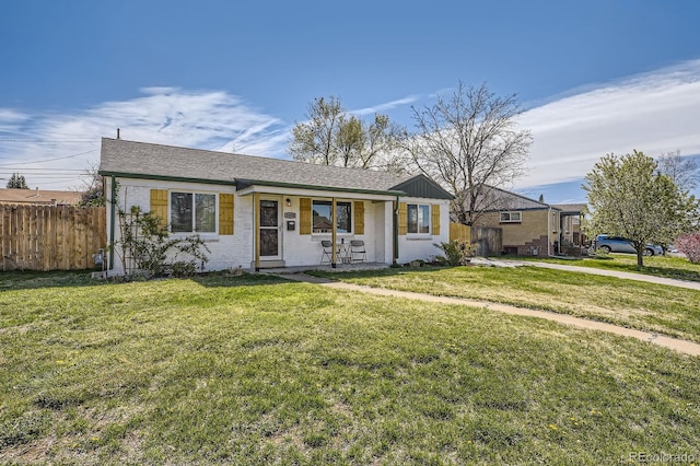 view of front of home featuring fence, covered porch, brick siding, and a front yard