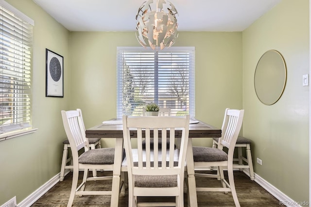 dining area featuring wood finished floors, visible vents, baseboards, and an inviting chandelier