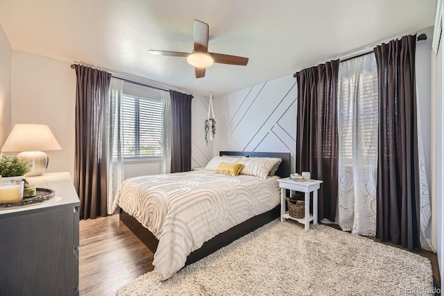 bedroom with a ceiling fan and light wood-style flooring