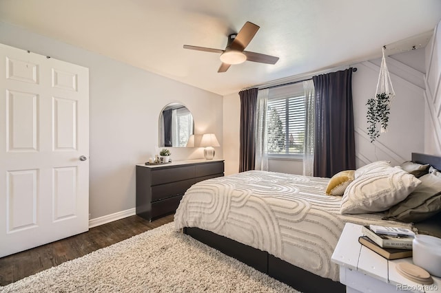 bedroom with a ceiling fan, baseboards, and dark wood-style flooring