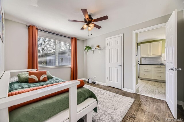 bedroom with baseboards, wood finished floors, and ceiling fan