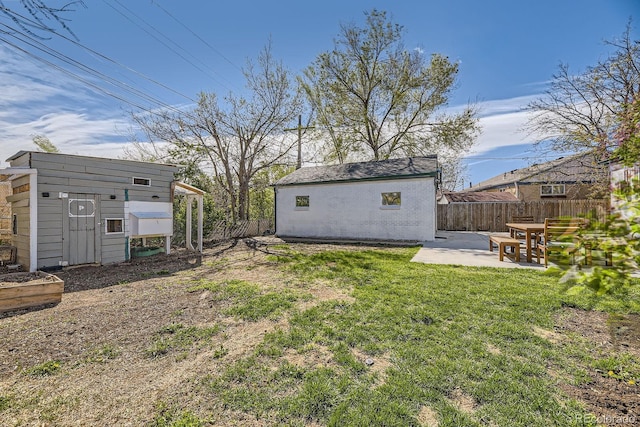 view of yard with a patio area, an outbuilding, and fence