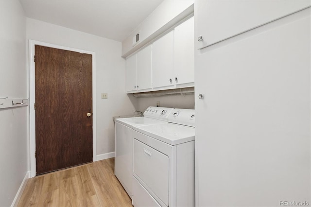 laundry area with light wood-style flooring, cabinet space, washing machine and clothes dryer, visible vents, and baseboards