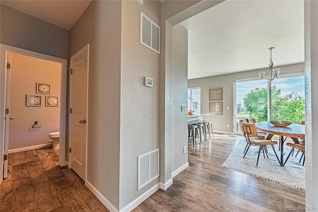 638 W 175th Ave, Broomfield, CO 80023 - hall with wood finished floors, a chandelier, and a textured wall