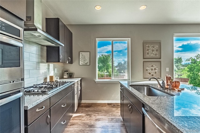 638 W 175th Ave, Broomfield, CO 80023 - kitchen with stainless steel appliances, wall chimney range hood, dark wood finished floors, recessed lighting, and light stone counters
