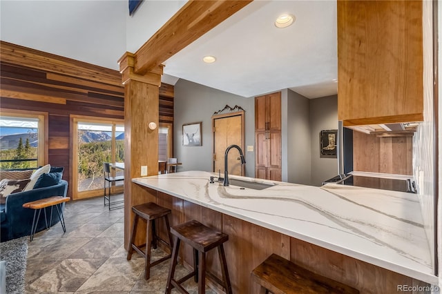 91200 Ryan Gulch Rd Unit 91222, Silverthorne, CO 80498 - kitchen with a sink, wooden walls, a peninsula, a breakfast bar area, and recessed lighting