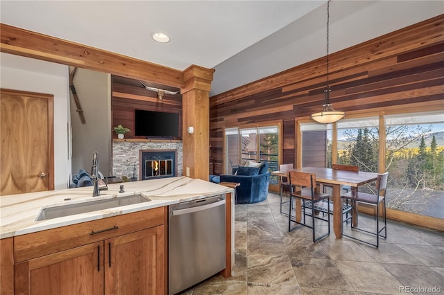91200 Ryan Gulch Rd Unit 91222, Silverthorne, CO 80498 - kitchen with dishwasher, open floor plan, wooden walls, a sink, and a glass covered fireplace