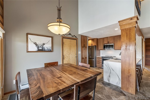 91200 Ryan Gulch Rd Unit 91222, Silverthorne, CO 80498 - dining area featuring a high ceiling and a baseboard radiator