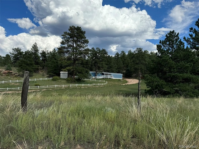 view of yard with a rural view and fence