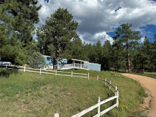 view of yard with fence and a rural view