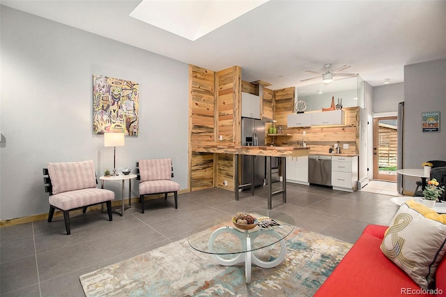 2530 Kensing Ct, Denver, CO 80211 - living area featuring dark tile patterned flooring, a ceiling fan, and a skylight