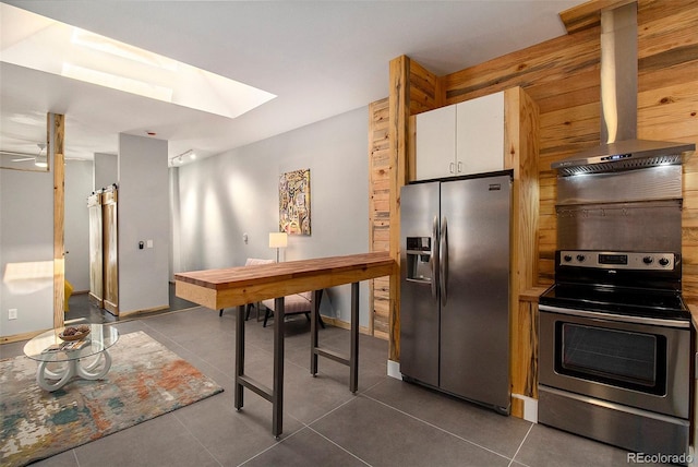 2530 Kensing Ct, Denver, CO 80211 - kitchen with appliances with stainless steel finishes, extractor fan, a skylight, dark tile patterned flooring, and white cabinetry
