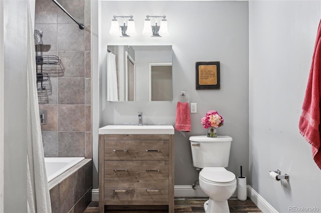 full bathroom featuring toilet, hardwood / wood-style flooring, vanity, and shower / tub combo