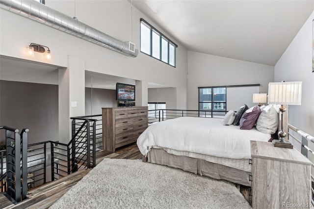 bedroom featuring dark hardwood / wood-style flooring and high vaulted ceiling