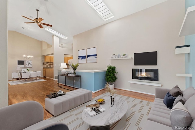 4195 W 111th Cir, Westminster, CO 80031 - living room featuring high vaulted ceiling, ceiling fan, a chandelier, wood finished floors, and a glass covered fireplace