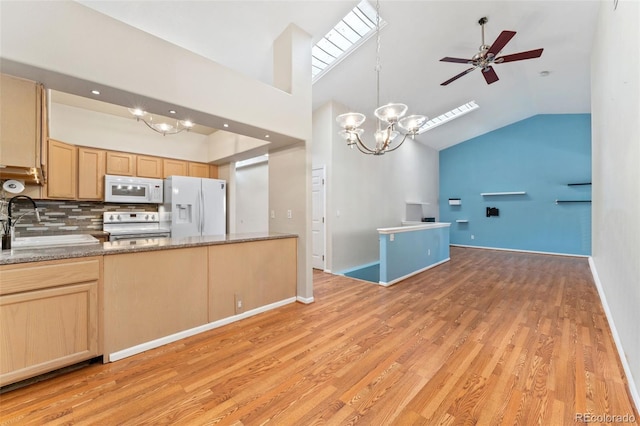4195 W 111th Cir, Westminster, CO 80031 - kitchen with white appliances, vaulted ceiling, light brown cabinetry, a sink, and ceiling fan