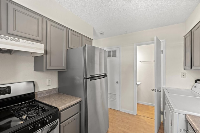 kitchen featuring gray cabinets, stainless steel refrigerator, black gas range oven, and light hardwood / wood-style flooring