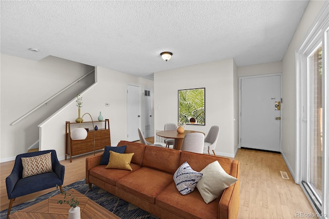 living room with light wood-type flooring and a textured ceiling