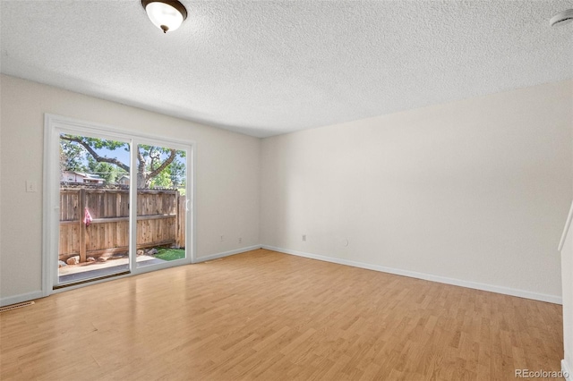 unfurnished room featuring a textured ceiling and light hardwood / wood-style flooring