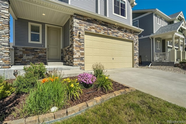 6689 Backcountry Loop, Colorado Springs, CO 80927 - property entrance with stone siding, an attached garage, and concrete driveway
