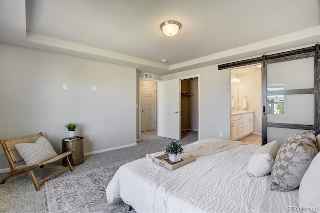 6689 Backcountry Loop, Colorado Springs, CO 80927 - bedroom with a barn door, light carpet, a spacious closet, connected bathroom, and a closet