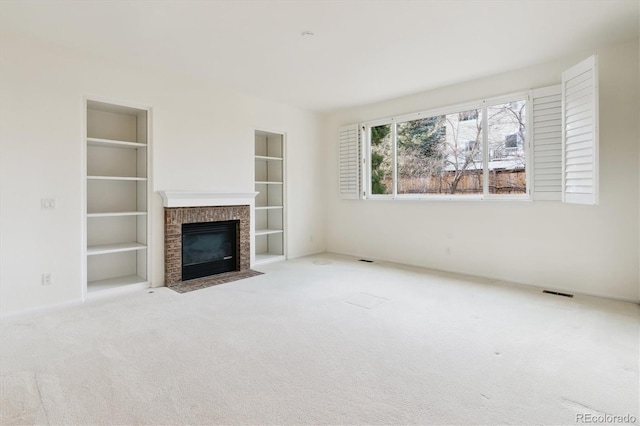 unfurnished living room with a fireplace, light carpet, and built in features