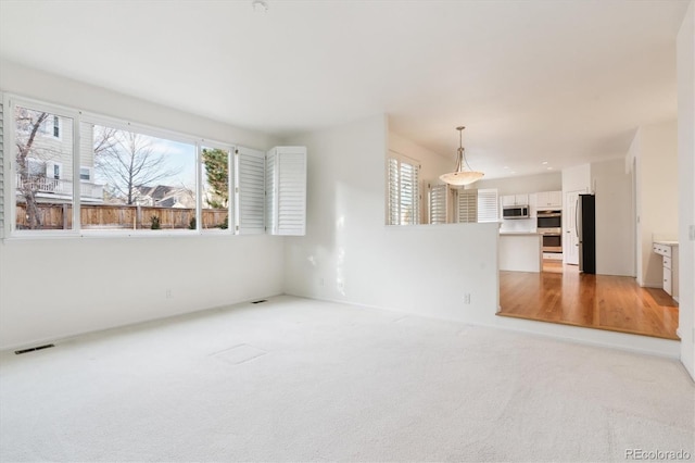 unfurnished living room with light colored carpet