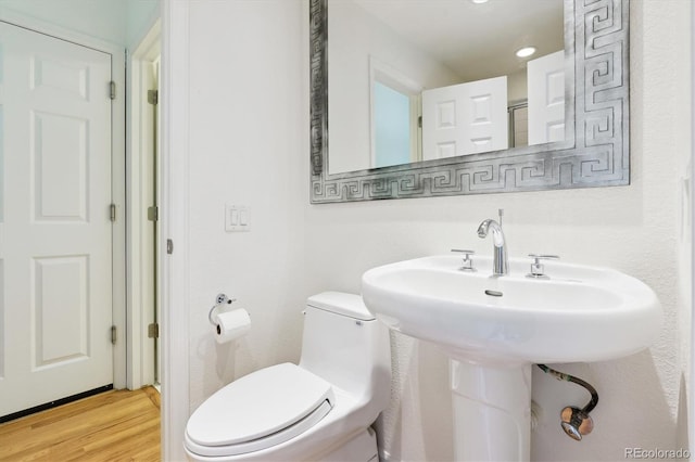 bathroom featuring wood-type flooring and toilet