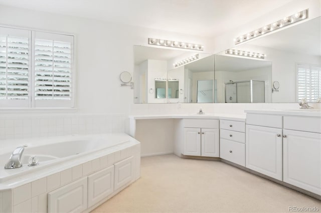 bathroom featuring vanity and independent shower and bath