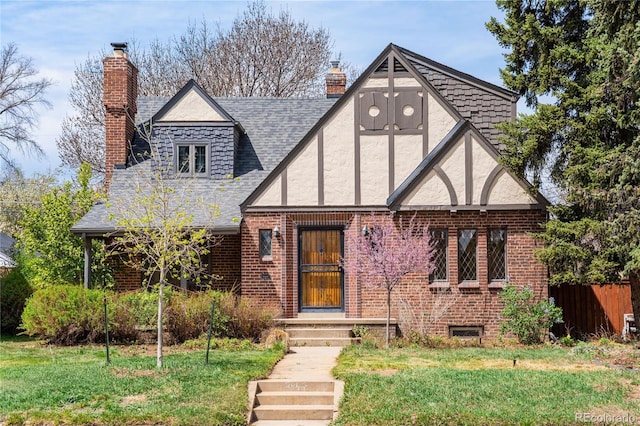 2285 N Monaco Pkwy, Denver, CO 80207 - english style home featuring a chimney, stucco siding, brick siding, and roof with shingles