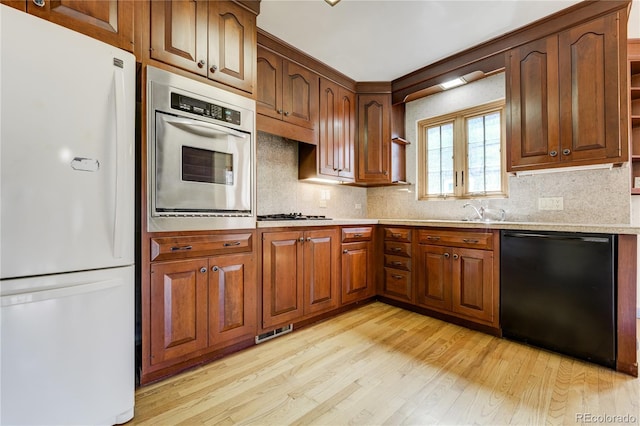 2285 N Monaco Pkwy, Denver, CO 80207 - kitchen featuring stainless steel appliances, light wood-style floors, light countertops, and decorative backsplash