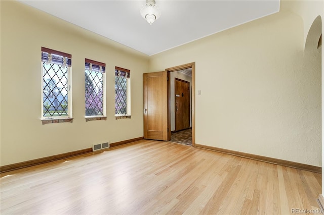 2285 N Monaco Pkwy, Denver, CO 80207 - unfurnished room with baseboards, light wood-style floors, and arched walkways
