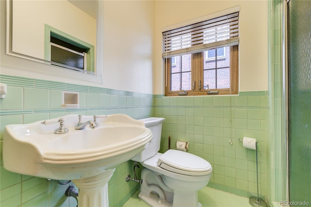 2285 N Monaco Pkwy, Denver, CO 80207 - bathroom with tile walls, a wainscoted wall, toilet, and tile patterned flooring