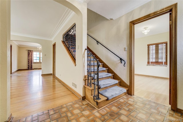 2285 N Monaco Pkwy, Denver, CO 80207 - staircase featuring arched walkways, crown molding, wood finished floors, and baseboards