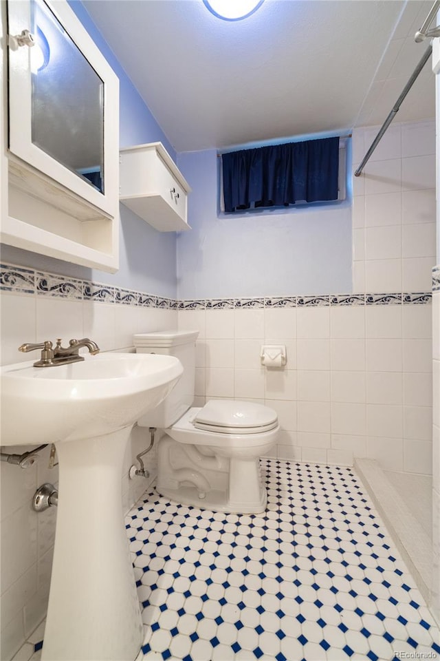2285 N Monaco Pkwy, Denver, CO 80207 - full bathroom featuring tile walls, toilet, tiled shower, and tile patterned flooring