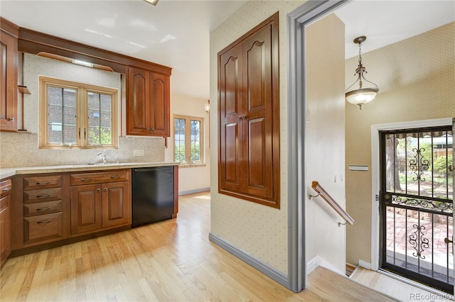 2285 N Monaco Pkwy, Denver, CO 80207 - kitchen with dishwasher, light wood-style flooring, wallpapered walls, light countertops, and tasteful backsplash