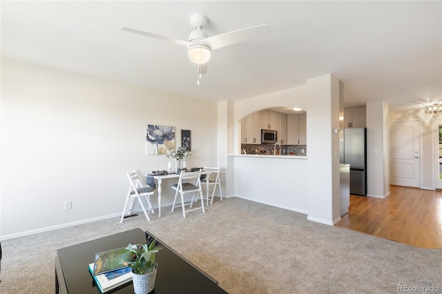 living room featuring ceiling fan and light colored carpet