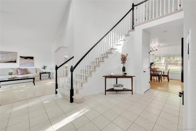 7420 S Houstoun Waring Cir, Littleton, CO 80120 - stairway with a towering ceiling, tile patterned flooring, and a chandelier