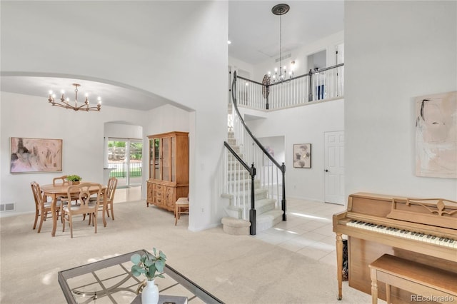 7420 S Houstoun Waring Cir, Littleton, CO 80120 - tiled living area with a chandelier, arched walkways, a high ceiling, stairway, and carpet floors