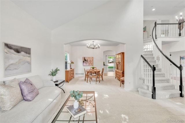 7420 S Houstoun Waring Cir, Littleton, CO 80120 - carpeted living room featuring arched walkways, a high ceiling, stairs, and a chandelier