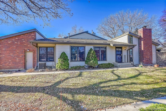 ranch-style home featuring a front lawn and central AC unit