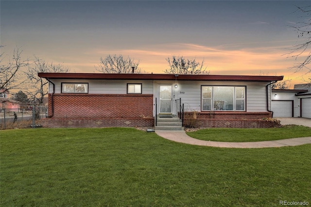 single story home featuring driveway, a front lawn, and brick siding