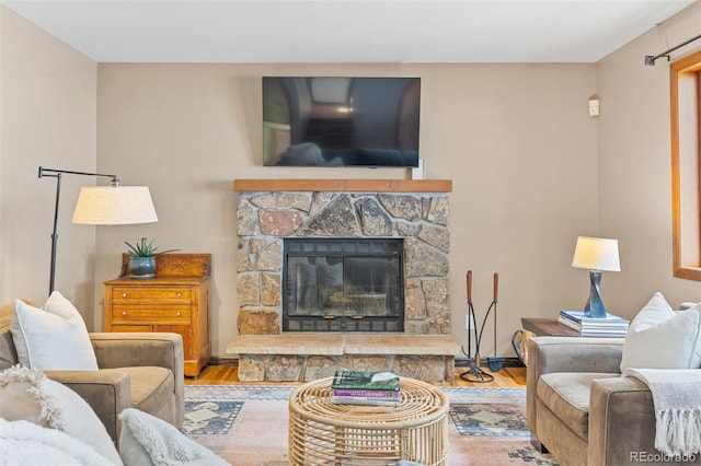 living room with a stone fireplace and hardwood / wood-style floors