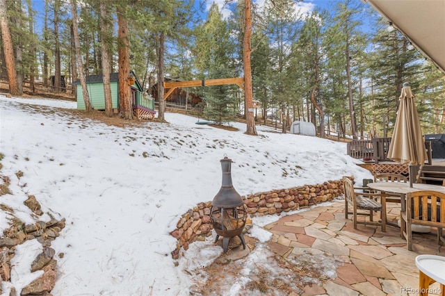 yard covered in snow with a storage shed