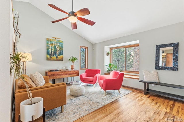 living room featuring ceiling fan, lofted ceiling, and light wood-type flooring