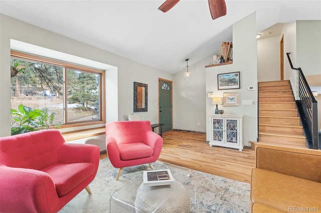 living room featuring hardwood / wood-style flooring, ceiling fan, and vaulted ceiling