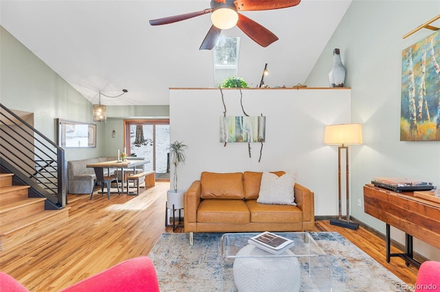 living room featuring ceiling fan, wood-type flooring, and vaulted ceiling